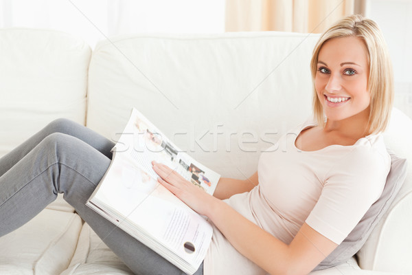 Stock photo: Blonde woman with a magazine in her living room