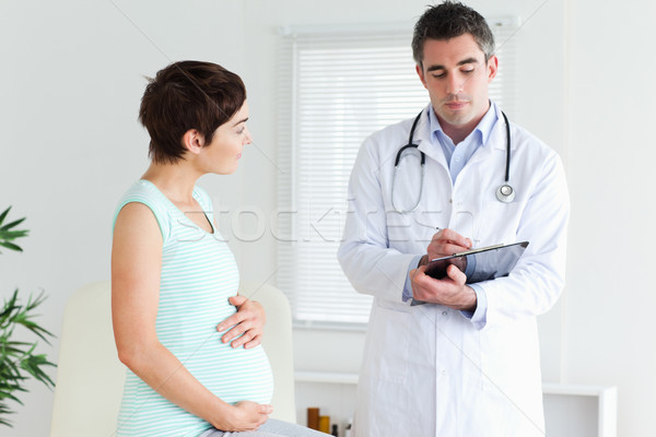 Pregnant woman talking to her doctor in a room Stock photo © wavebreak_media