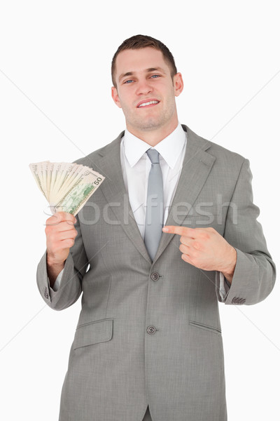 Portrait of a businessman pointing at a wad of cash against a white background Stock photo © wavebreak_media