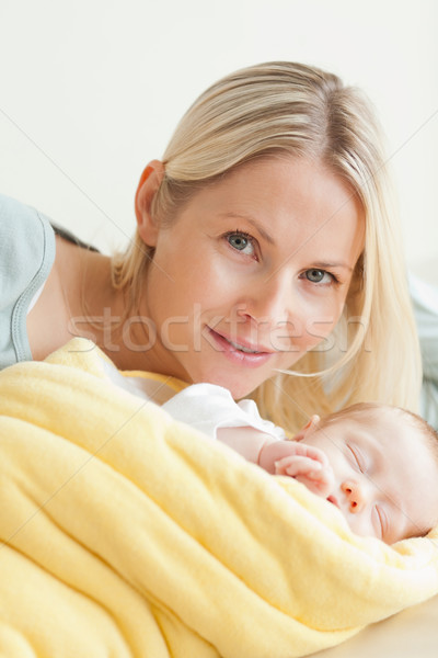Young smiling mother relaxing next to her sleeping baby Stock photo © wavebreak_media