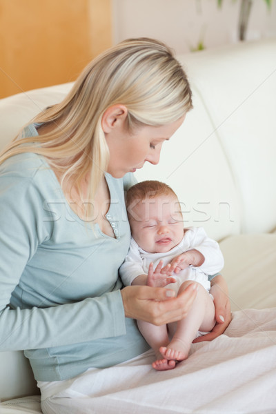 Young mother on the sofa with her baby on her lap Stock photo © wavebreak_media