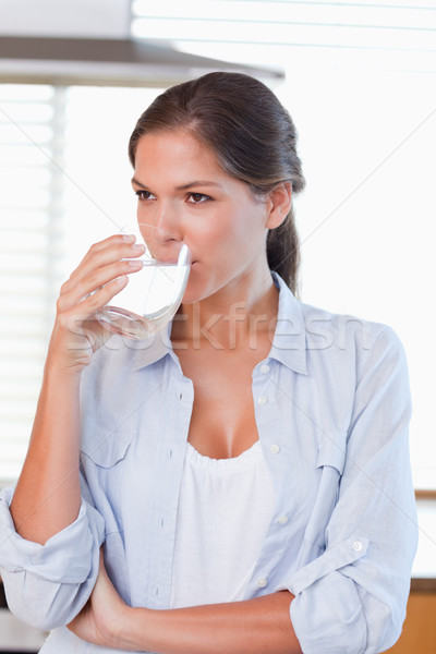 Portrait of a woman drinking a glass of water in her kitchen Stock photo © wavebreak_media