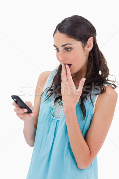Portrait of a surprised woman reading a text message against a white background Stock photo © wavebreak_media