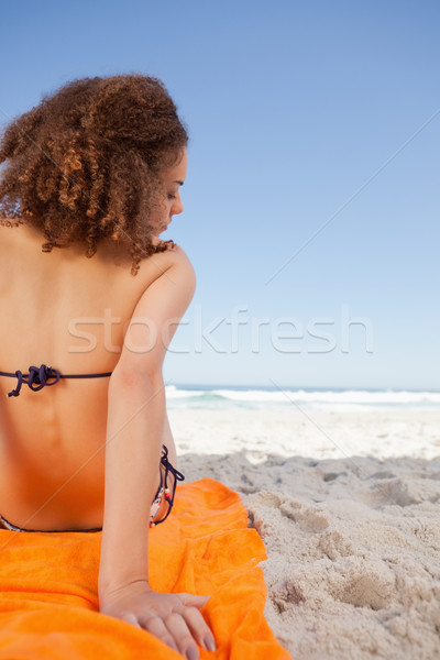 Jovem bela mulher sessão laranja toalha de praia Foto stock © wavebreak_media