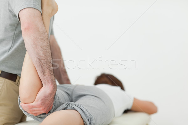 Woman lying forward while a man is stretching her leg in a room Stock photo © wavebreak_media