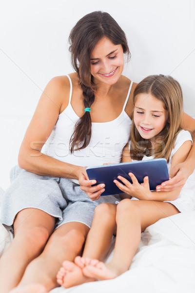 Foto stock: Mãe · filha · comprimido · cama · mulher · menina