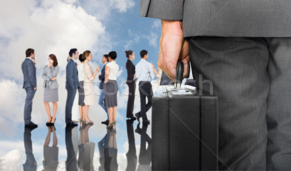 Stock photo: Composite image of businessman holding briefcase