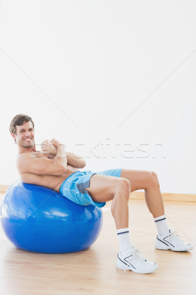 Shirtless man exercising on fitness ball in gym Stock photo © wavebreak_media