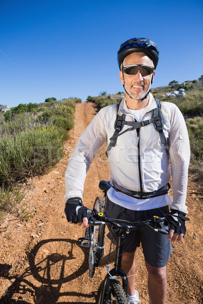 Fit cyclist smiling at the camera on country terrain Stock photo © wavebreak_media