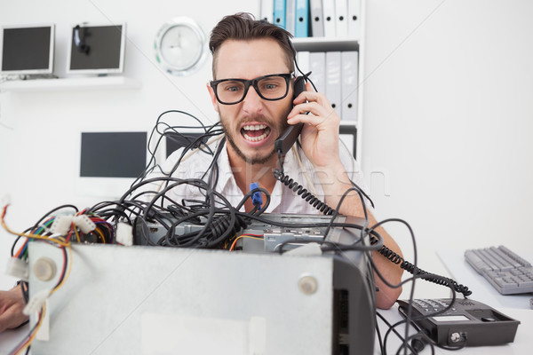 Stock photo: Angry computer engineer making a call