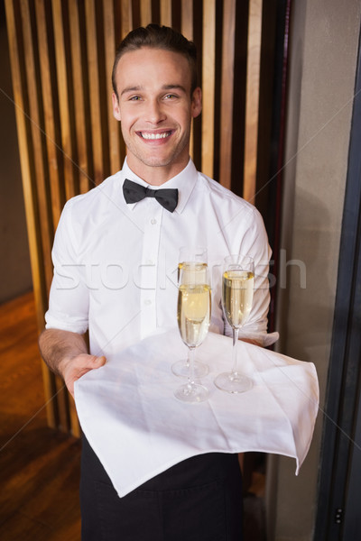 Jóképű mosolyog pincér tart tálca pezsgő Stock fotó © wavebreak_media