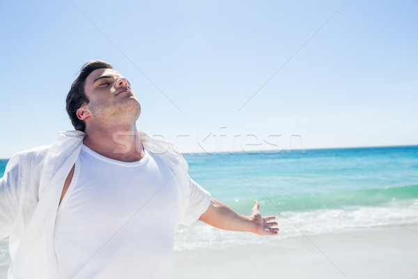 Man stretching his arms in front of the sea Stock photo © wavebreak_media