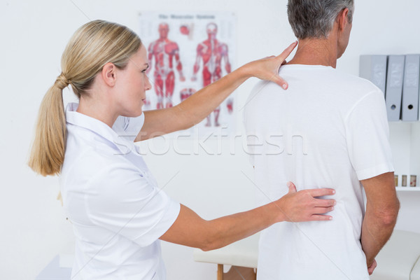 Doctor examining her patient back  Stock photo © wavebreak_media