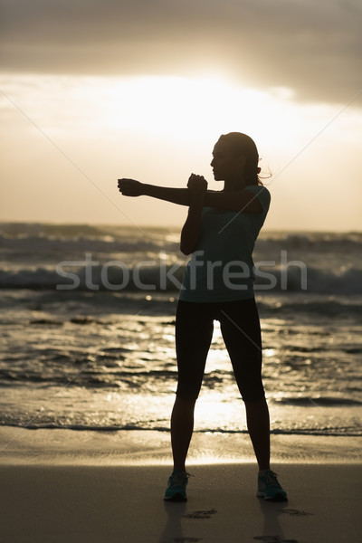 Sporty brunette stretching on the beach  Stock photo © wavebreak_media