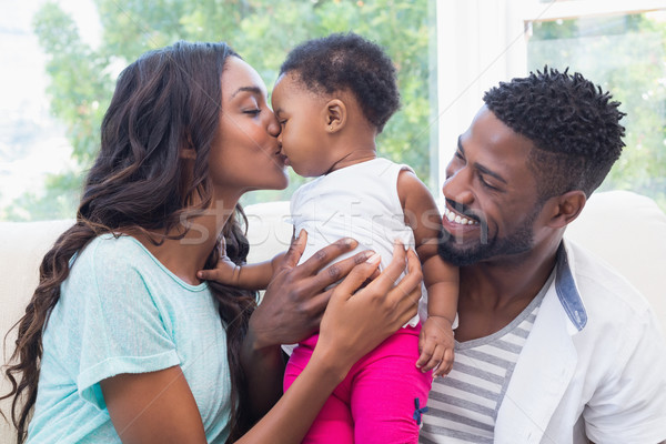 Stock photo: Happy parents with baby girl on couch