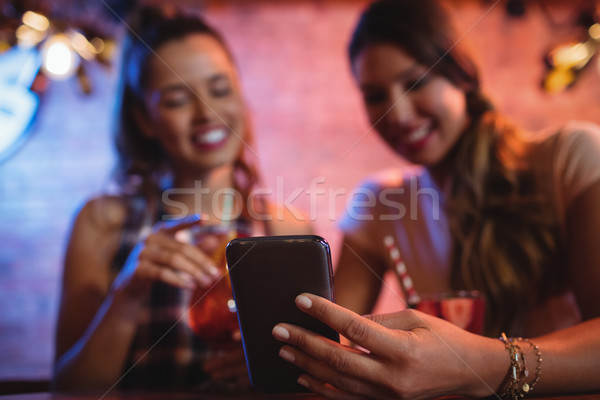 Twee jonge vrouwen mobiele telefoon pub vrouw bar Stockfoto © wavebreak_media