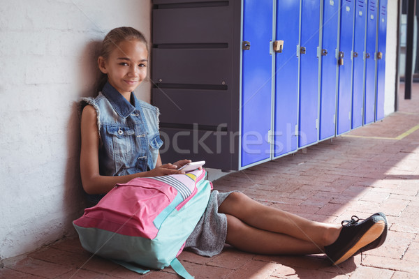 Portré alapfokú iskolás lány mobiltelefon ül járda Stock fotó © wavebreak_media