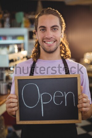 Stock photo: Portrait of smiling young pretty waitress holding digital tablet