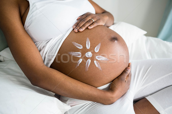 Mujer embarazada crema vientre casa cama Foto stock © wavebreak_media