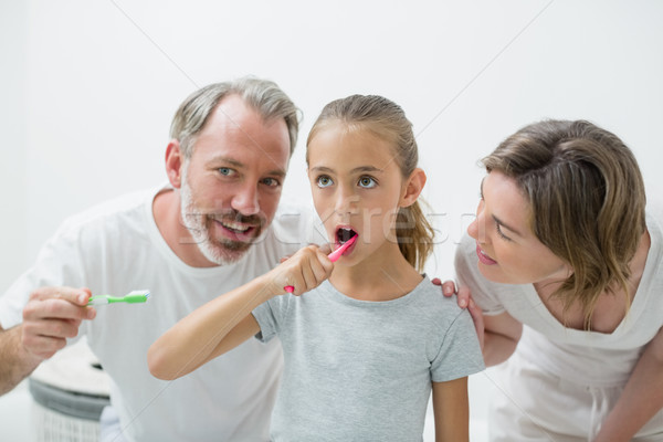 Smiling family brushing their teeth with toothbrush Stock photo © wavebreak_media