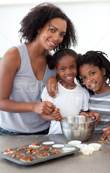 Stock photo: Cute siblings with their mother making biscuits