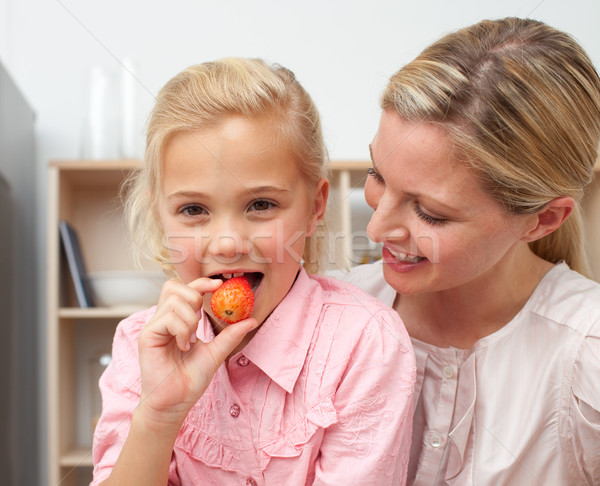 Lively little girl eating fruit with her mother Stock photo © wavebreak_media