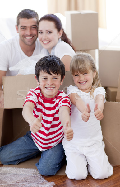 Family moving house with boxes and thumbs up Stock photo © wavebreak_media