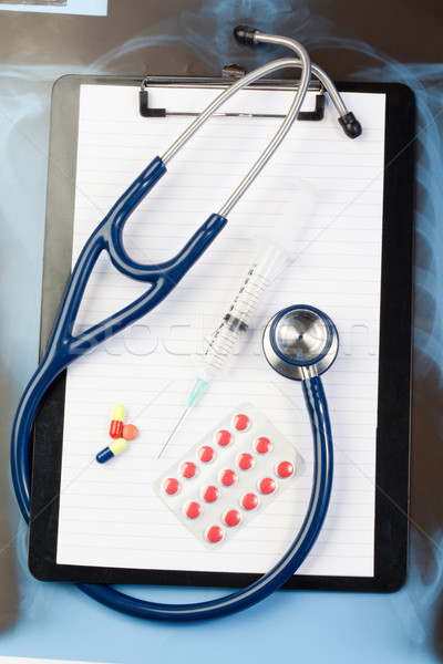 Note pad and blister strip with pills and blue stethoscope on a blue and dark background Stock photo © wavebreak_media