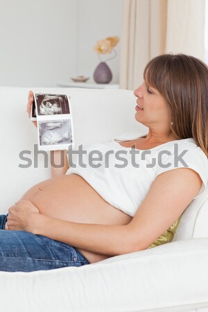 Encantador mulher grávida olhando ultra-som esquadrinhar sofá Foto stock © wavebreak_media