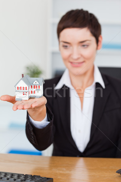 Portrait of a businesswoman showing a miniature house in her office Stock photo © wavebreak_media
