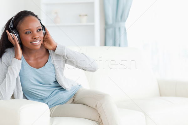 Сток-фото: улыбающаяся · женщина · музыку · диван · звук · наушников · гарнитура