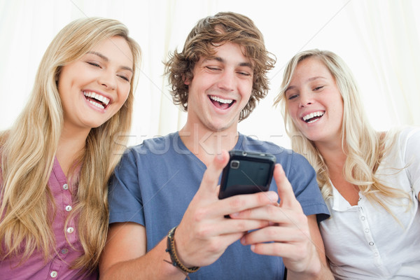 Trois souriant amis s'asseoir ensemble Rechercher [[stock_photo]] © wavebreak_media