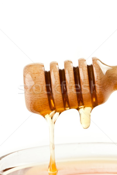 Honey trickle on the top of a honey full bowl against a white background Stock photo © wavebreak_media