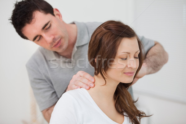 Smiling woman sitting while being massaged by a man in a room Stock photo © wavebreak_media