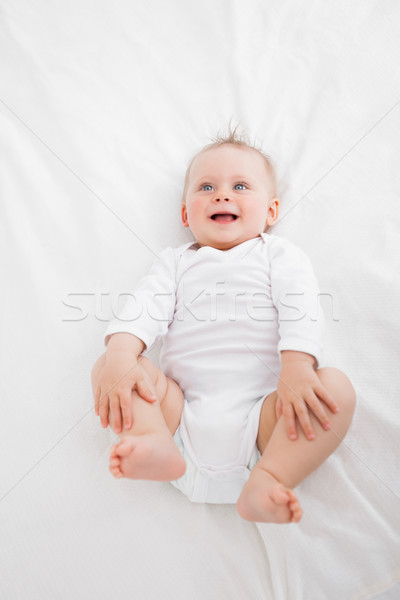 Little baby laughing while lying on a blanket indoors Stock photo © wavebreak_media