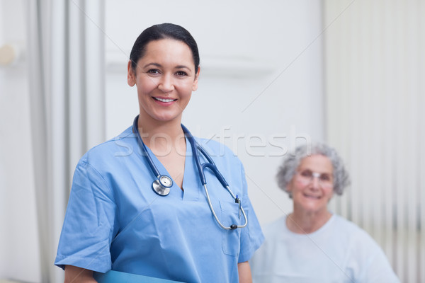 Stock photo: Nurse and a patient looking at camera in hospital ward