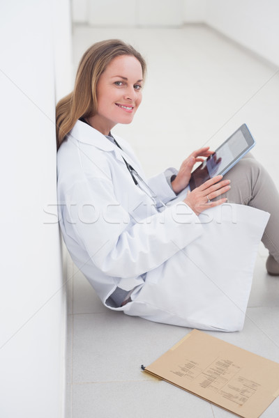 Doctor using an ebook while sitting in hospital ward Stock photo © wavebreak_media