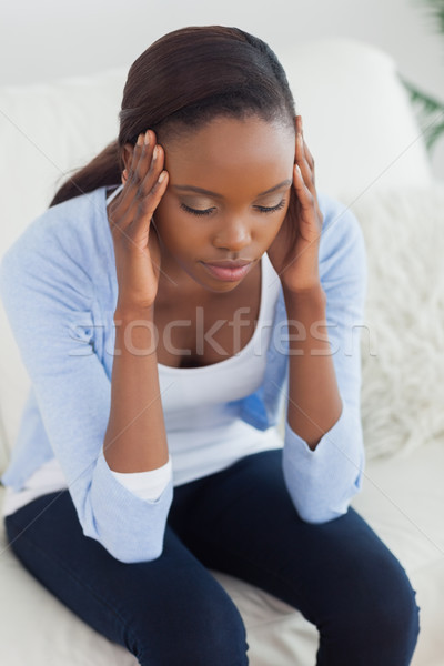 Close up of a black woman holding her head in a living room Stock photo © wavebreak_media