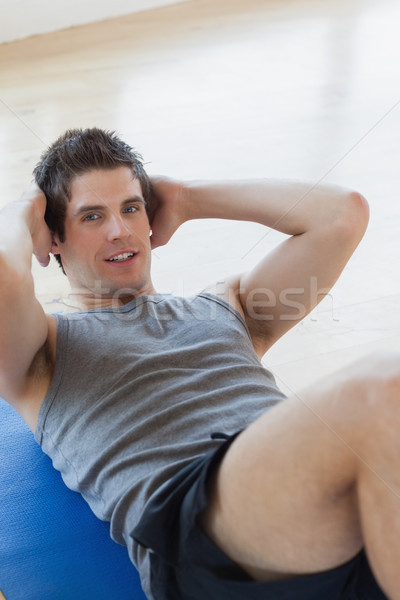 Stock photo: Man doing sit ups at the gym