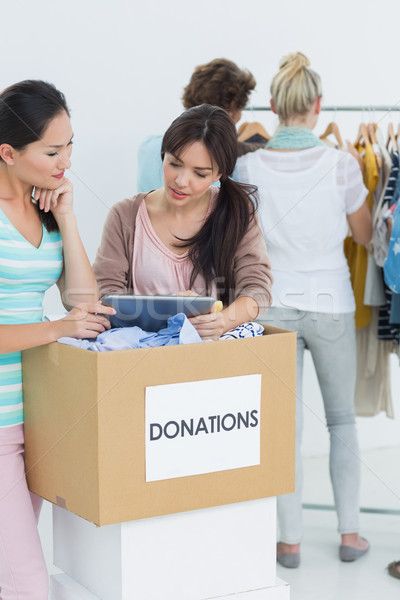 Stock photo: People with clothes donation while using digital tablet