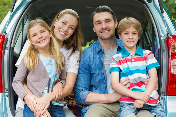 Portrait of happy family of four sitting in car trunk Stock photo © wavebreak_media