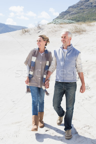 Stock photo: Attractive couple standing holding hands on the beach