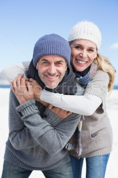 Attractive couple hugging and smiling at camera on the beach in  Stock photo © wavebreak_media