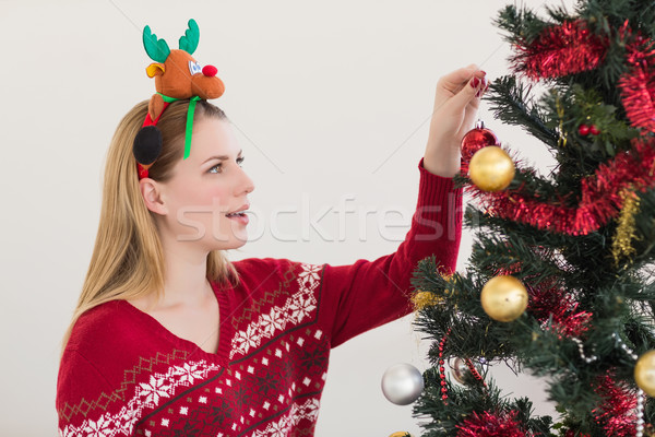 Woman hanging christmas decorations on tree Stock photo © wavebreak_media