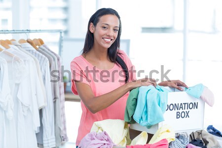 Smiling young female volunteer separating clothes Stock photo © wavebreak_media