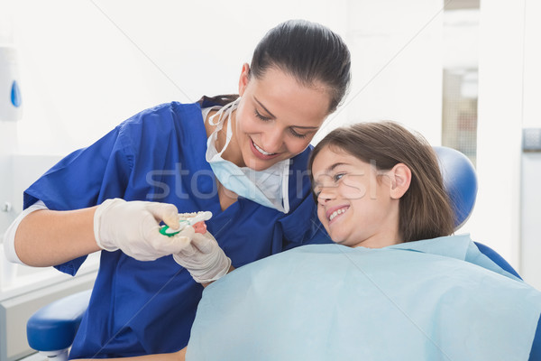 Pediatric dentist explaining to young patient how use toothbrush Stock photo © wavebreak_media