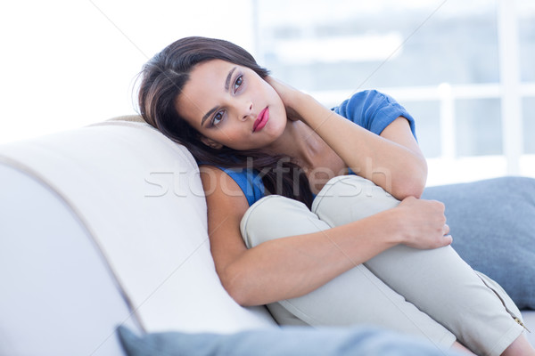 Thoughtful beautiful brunette sitting on the couch Stock photo © wavebreak_media