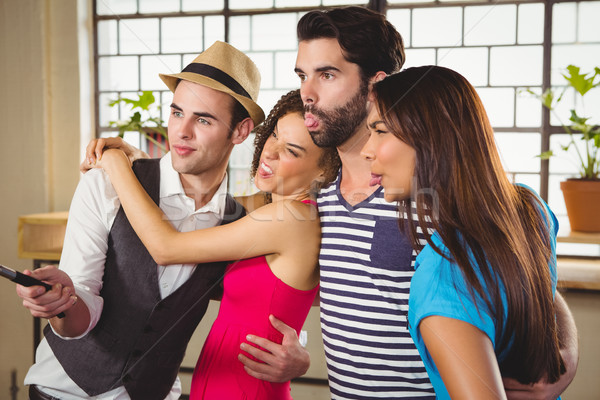  Grimacing friends taking selfies with selfiestick Stock photo © wavebreak_media