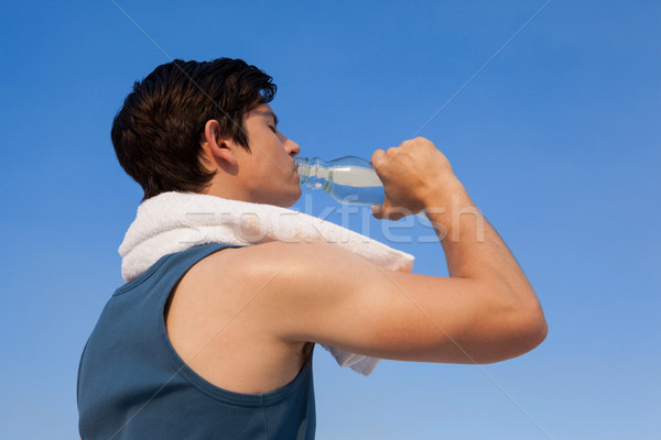 Man drinking water from bottle against blue sky Stock photo © wavebreak_media