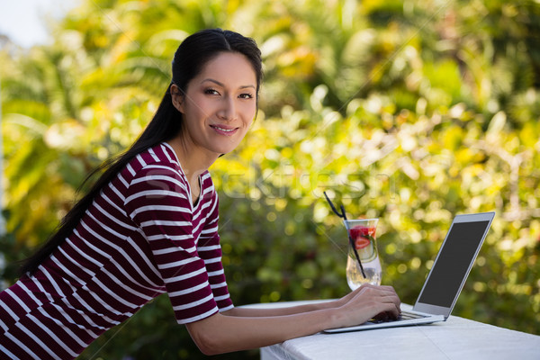 Portrait of young woman using laptop at restaurant Stock photo © wavebreak_media